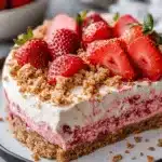 Close-up of a berrylicious strawberry crunch cheesecake with vibrant strawberry filling, cream layers, and buttery graham cracker crust.